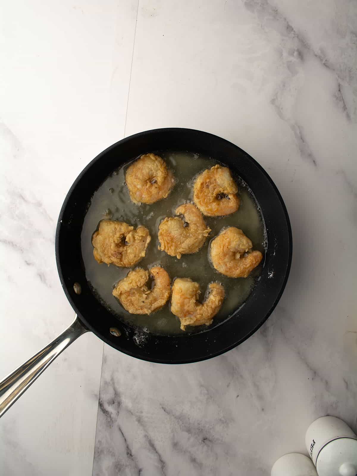 Shrimp frying in hot oil until golden.
