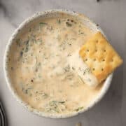 chimichurri aioli served in a bowl and dipped with cracker