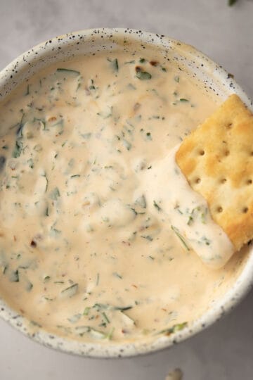 chimichurri aioli served in a bowl and dipped with cracker