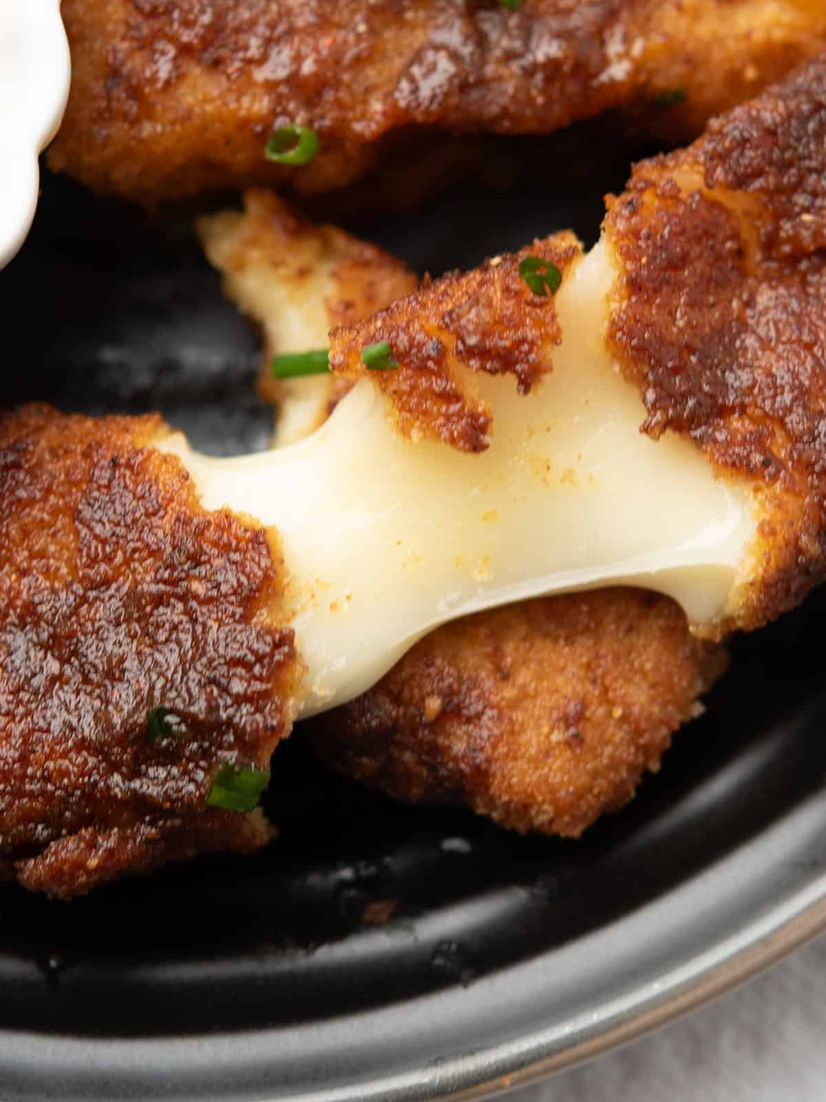Close-up of crispy Nashville hot mozzarella sticks with excellent cheese pull