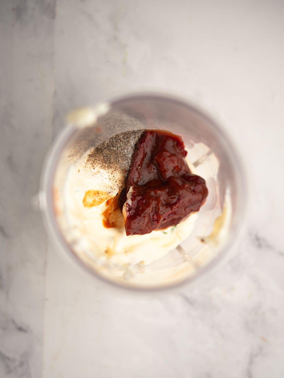 Blender filled with mayonnaise and chipotle peppers for the sauce.