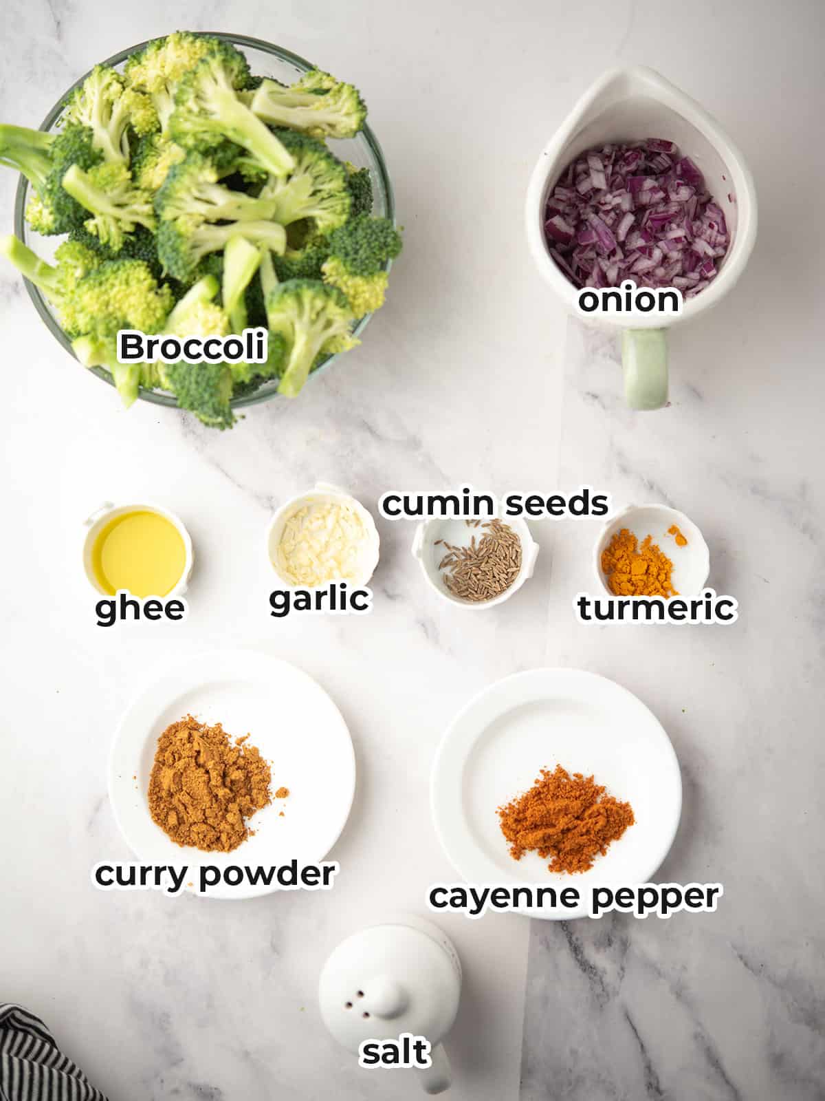 Fresh broccoli florets, oil, spices, onion, and garlic for curried broccoli.