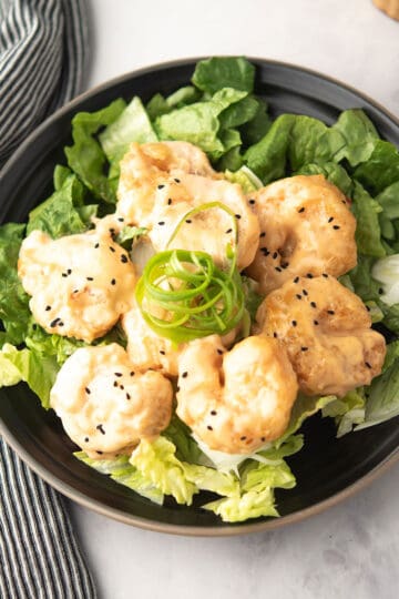 pf chang inspired cirpsy shrimp coated with Asian sauce, the dynamite shrimp served in a plate