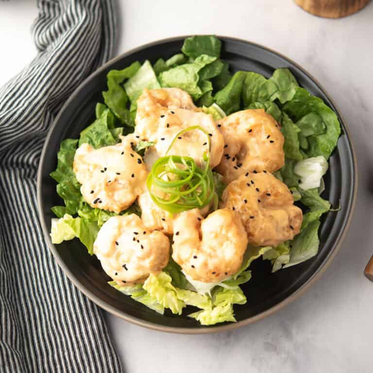 pf chang inspired cirpsy shrimp coated with Asian sauce, the dynamite shrimp served in a plate