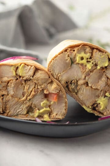 Close-up of a sliced honey mustard chicken wrap showing layers.