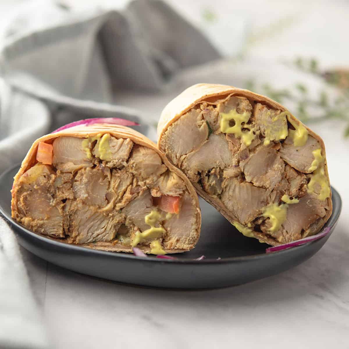 Close-up of a sliced honey mustard chicken wrap showing layers.
