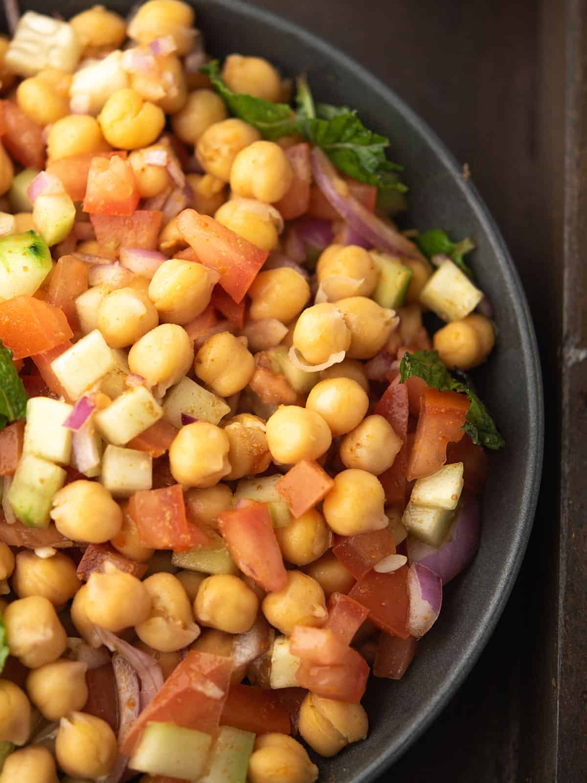 Close-up of healthy Indian chickpea salad garnished with mint leaves
