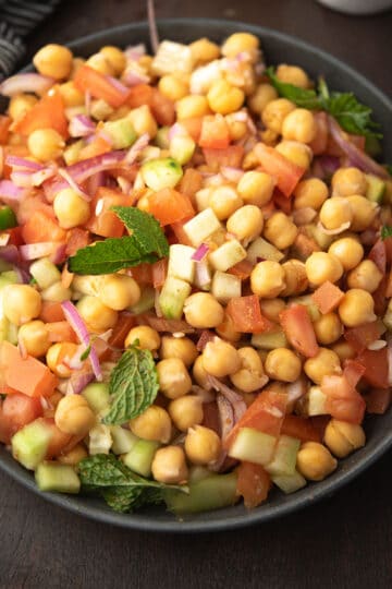 Indian chickpea salad in a plate garnished with mint leaves.