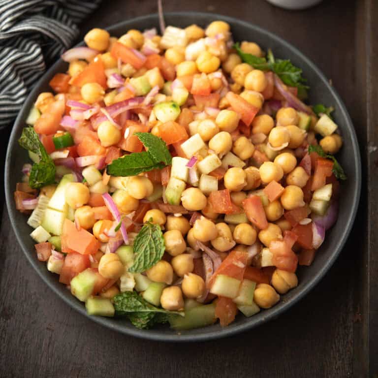 Indian chickpea salad in a plate garnished with mint leaves.