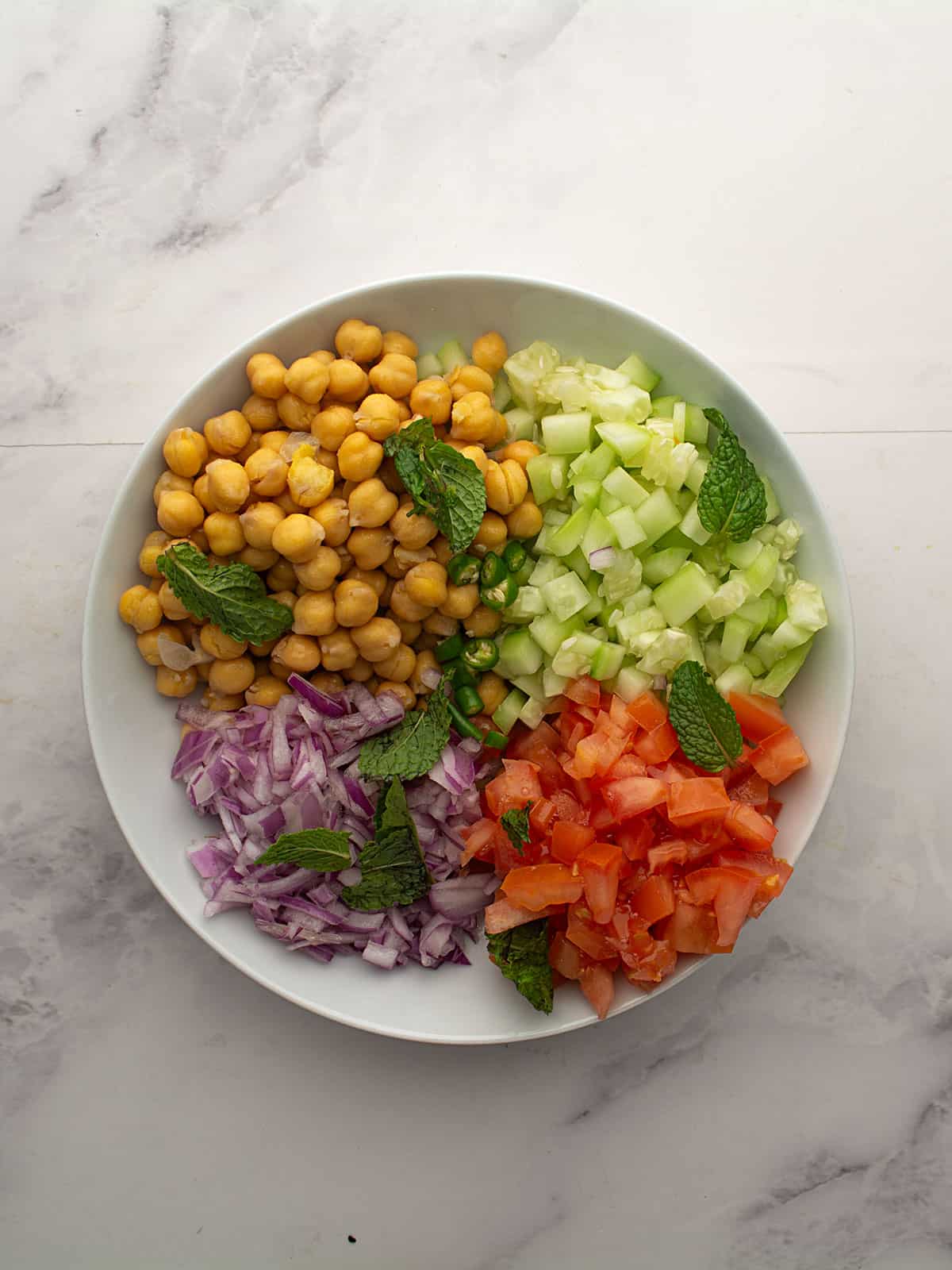 Chickpeas and diced vegetables in a large mixing bowl