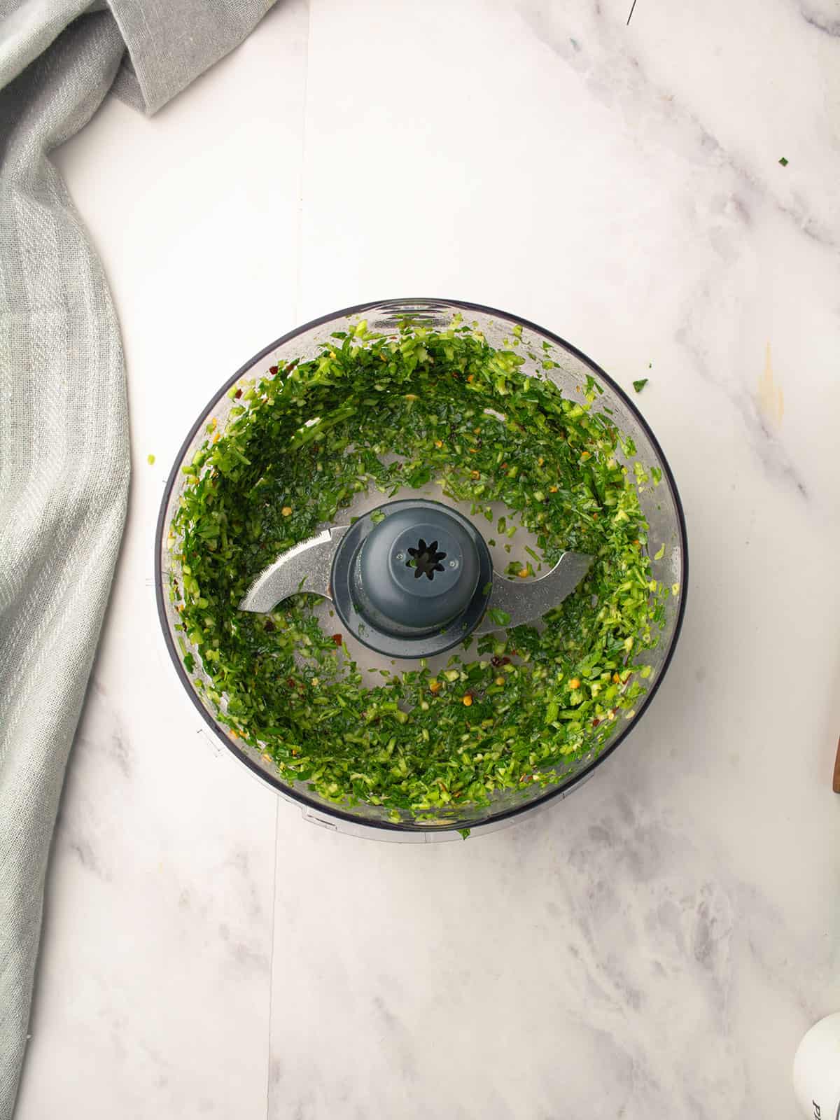 Chimichurri sauce ingredients combined in a food processor