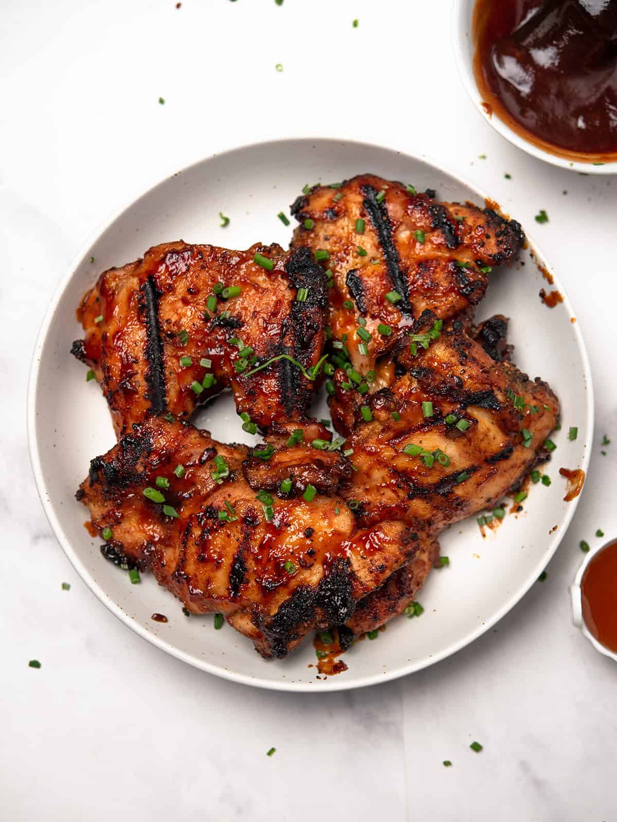 BBQ boneless chicken thighs served with sauce on a plate