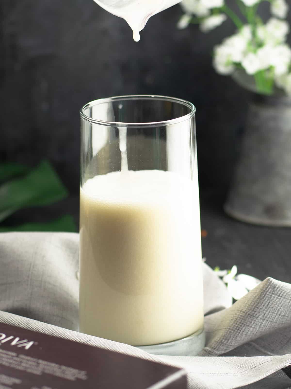 transferring the coconut milk banana smoothie to a glass