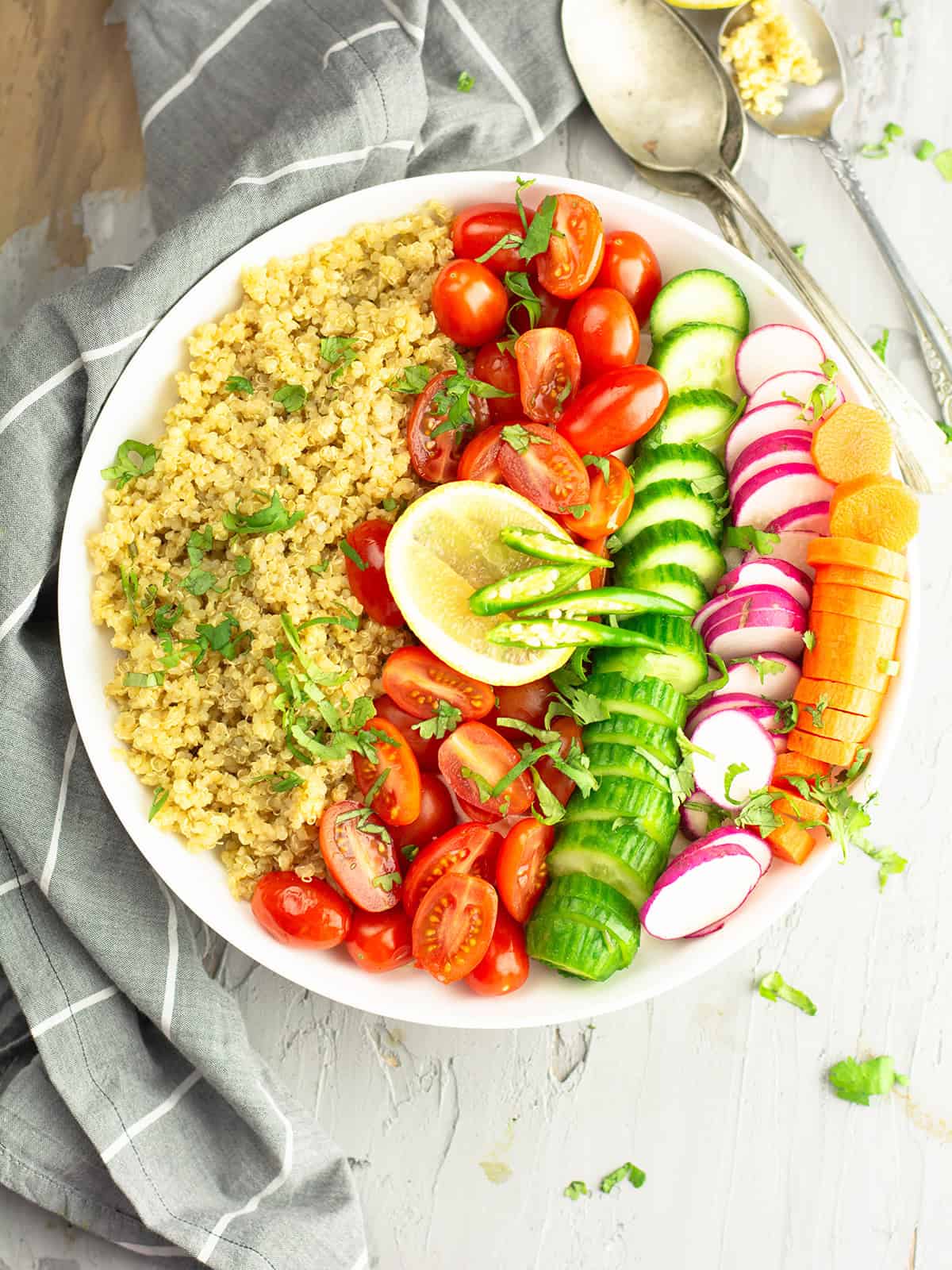 indian quinoa salad served in a plate garnished with lemon slices and green chili