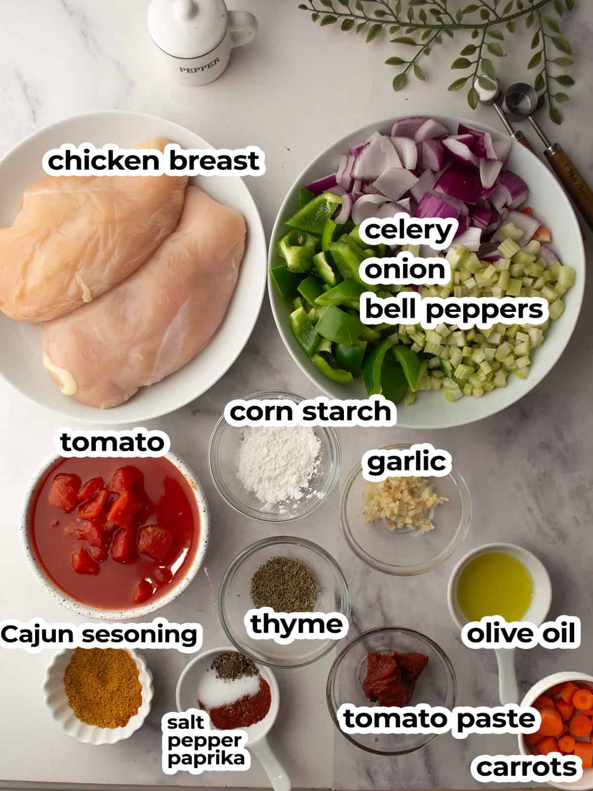 Fresh ingredients for Cajun chicken stew including chicken, spices, and vegetables.