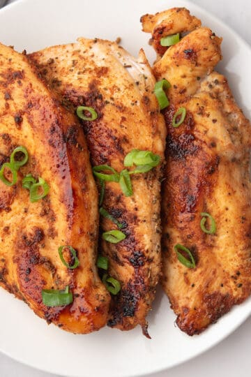 baked thin chicken breast with golden edges, perfectly spiced and served in a plate