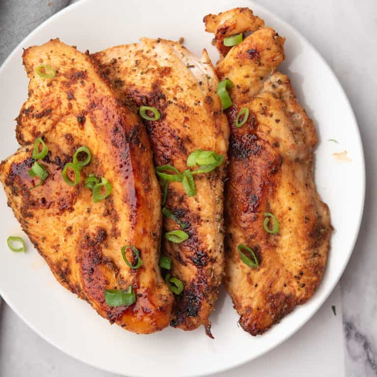 baked thin chicken breast with golden edges, perfectly spiced and served in a plate