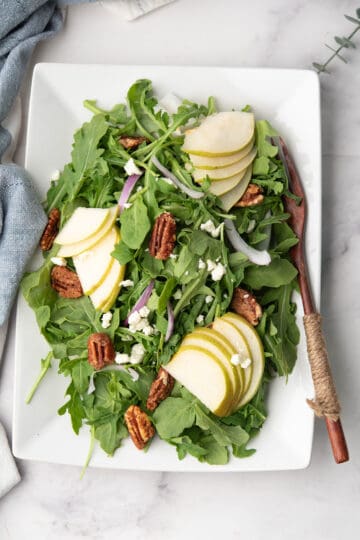 Arugula pear salad topped with goat cheese and candied walnuts.