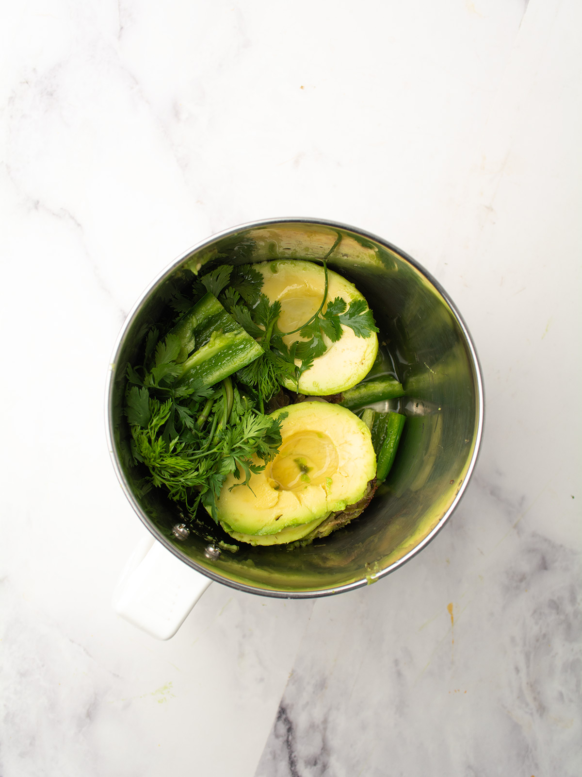 Avocado, sour cream, lime juice, and spices in blender ready to mix