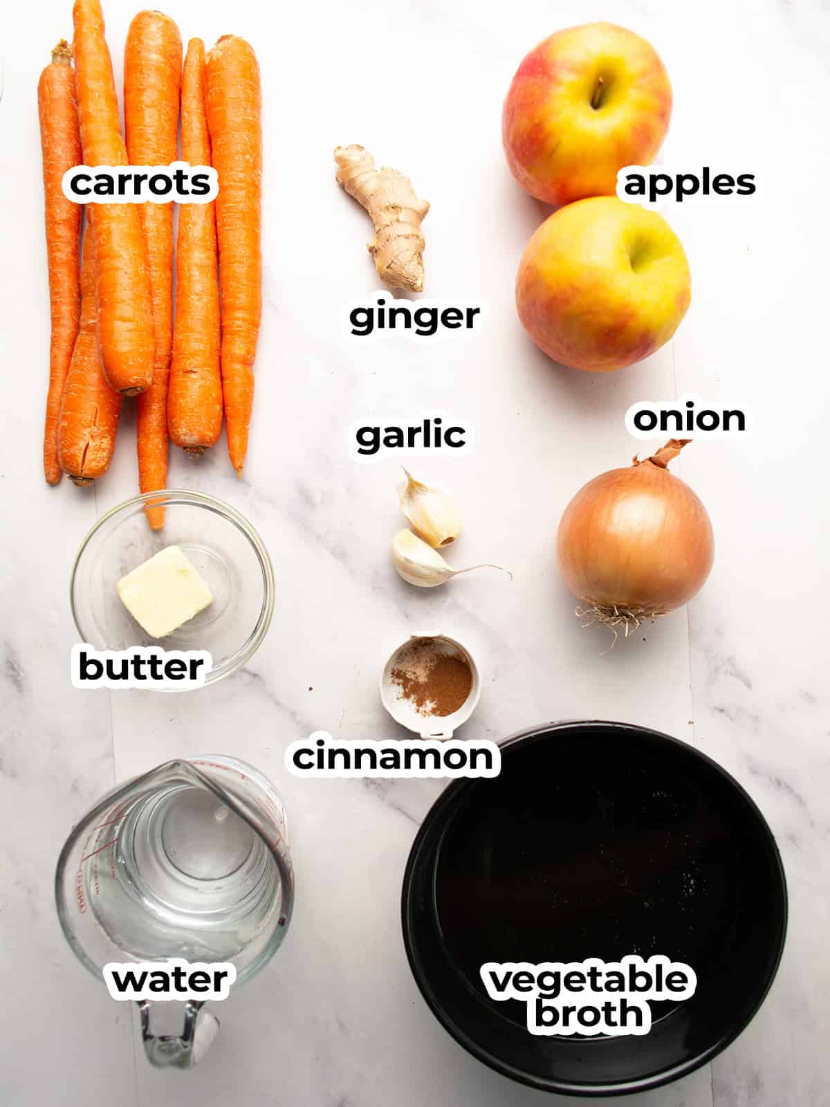 Ingredients for carrot apple ginger soup: carrots, apples, ginger, garlic, and spices