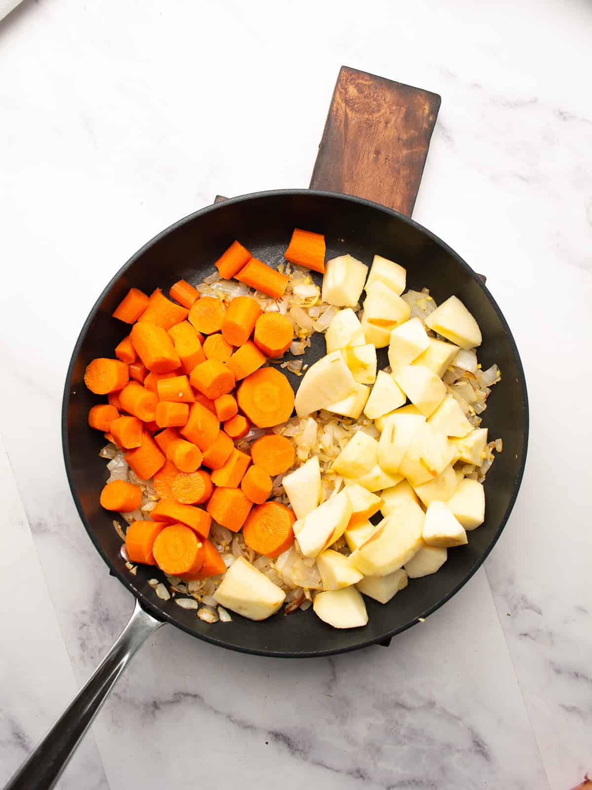 Chopped carrots and apples added to the pot for the soup