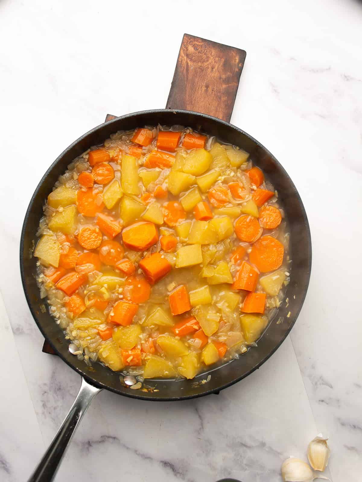 Simmering carrot apple ginger soup in a large pot.