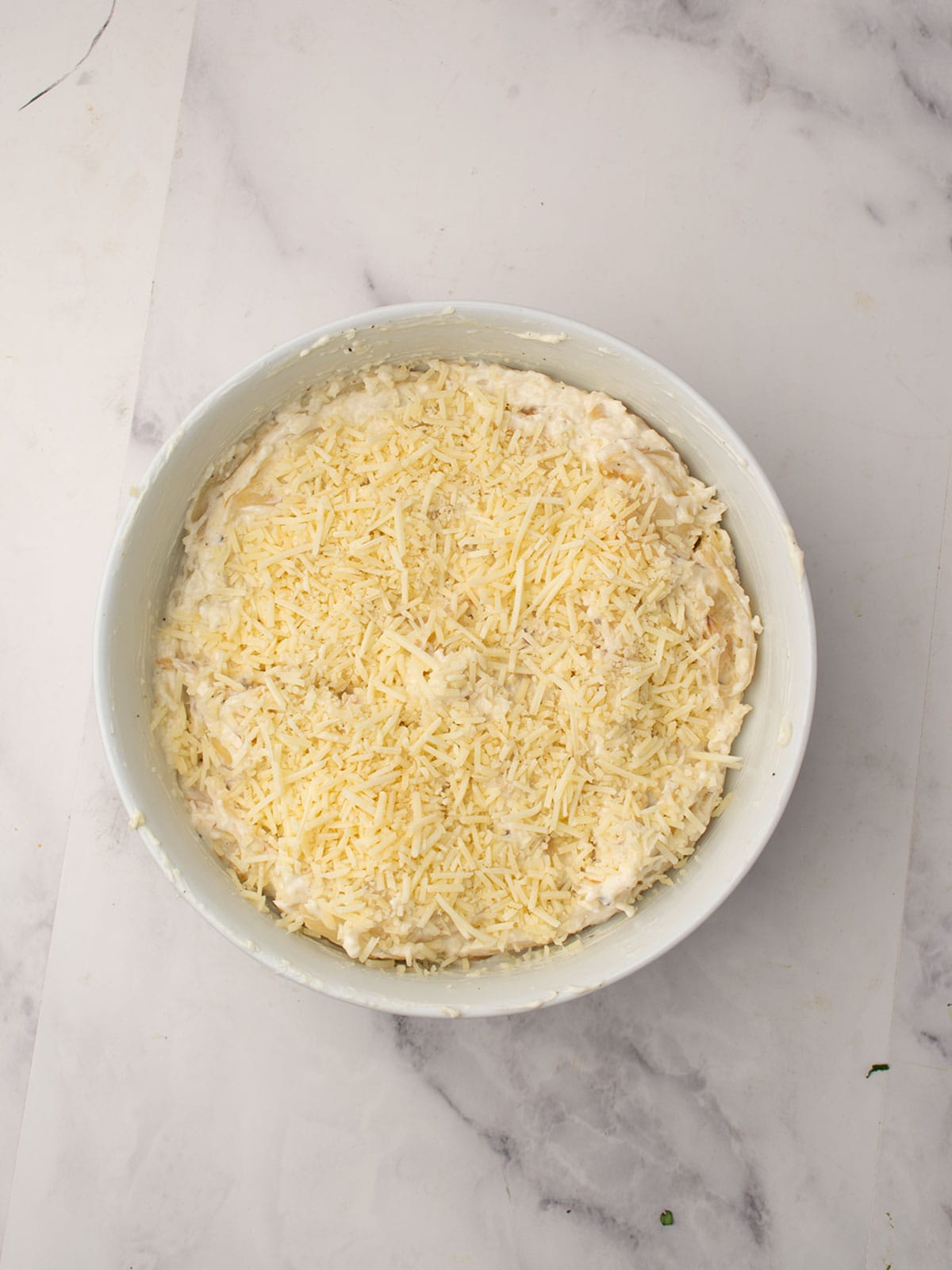finishing the bake dish with grated parmesan