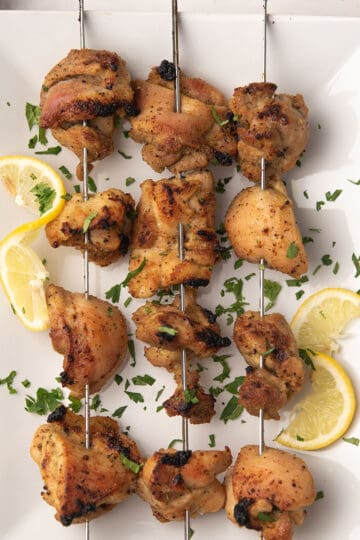 lemon pepper chicken skewers served with lemon slices