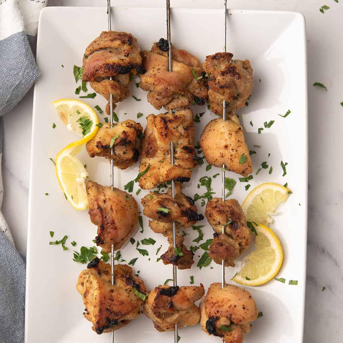 lemon pepper chicken skewers served with lemon slices
