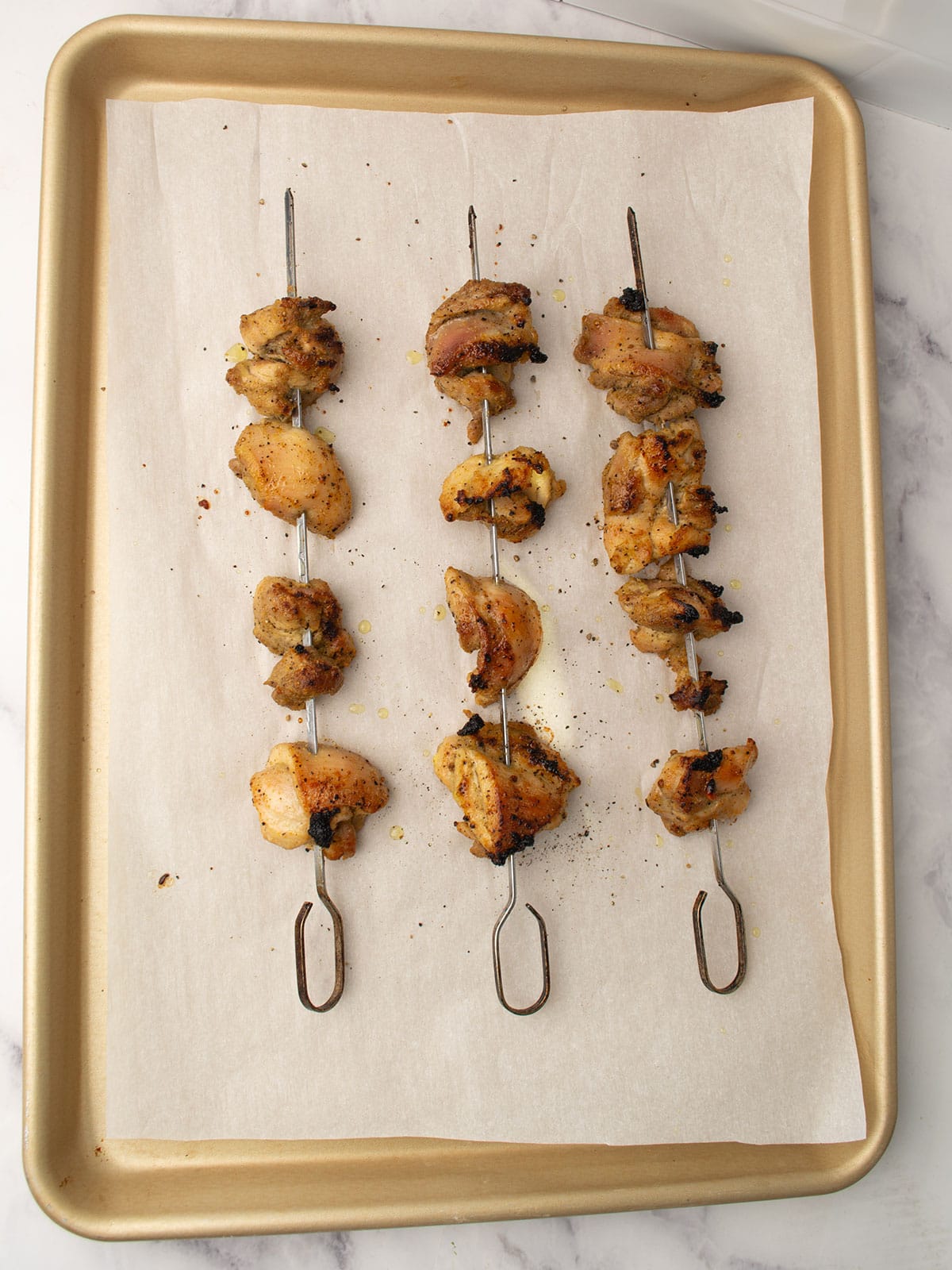 Grilling lemon pepper chicken skewers on a the oven.