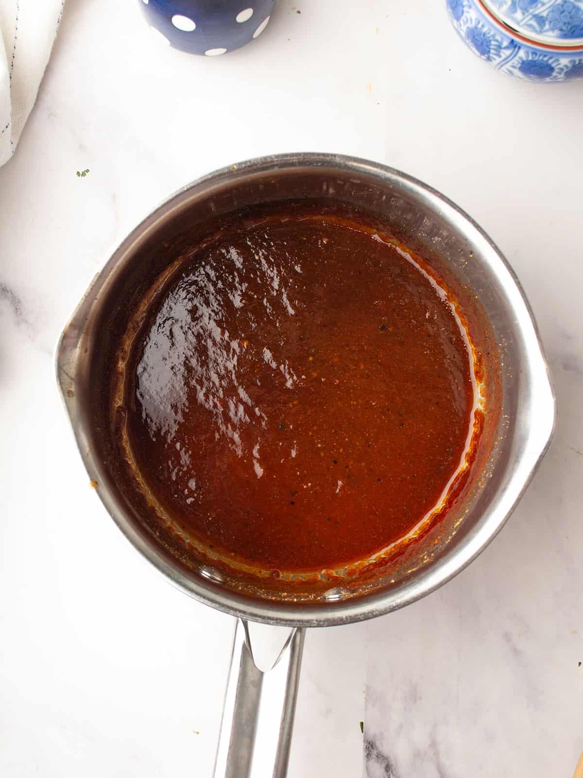 Mixing pineapple, barbecue sauce, and soy sauce in a pan.