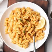 red pepper pasta is served in a plate for the weeknight dinner with a fork