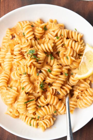 red pepper pasta is served in a plate for the weeknight dinner with a fork