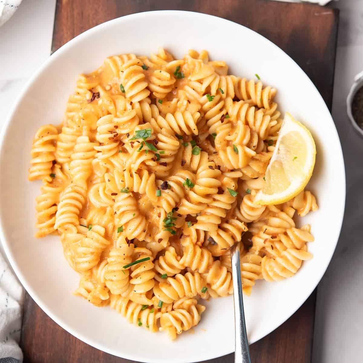 red pepper pasta is served in a plate for the weeknight dinner with a fork