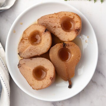 spiced pears are placed in a plate to serve as the dessert
