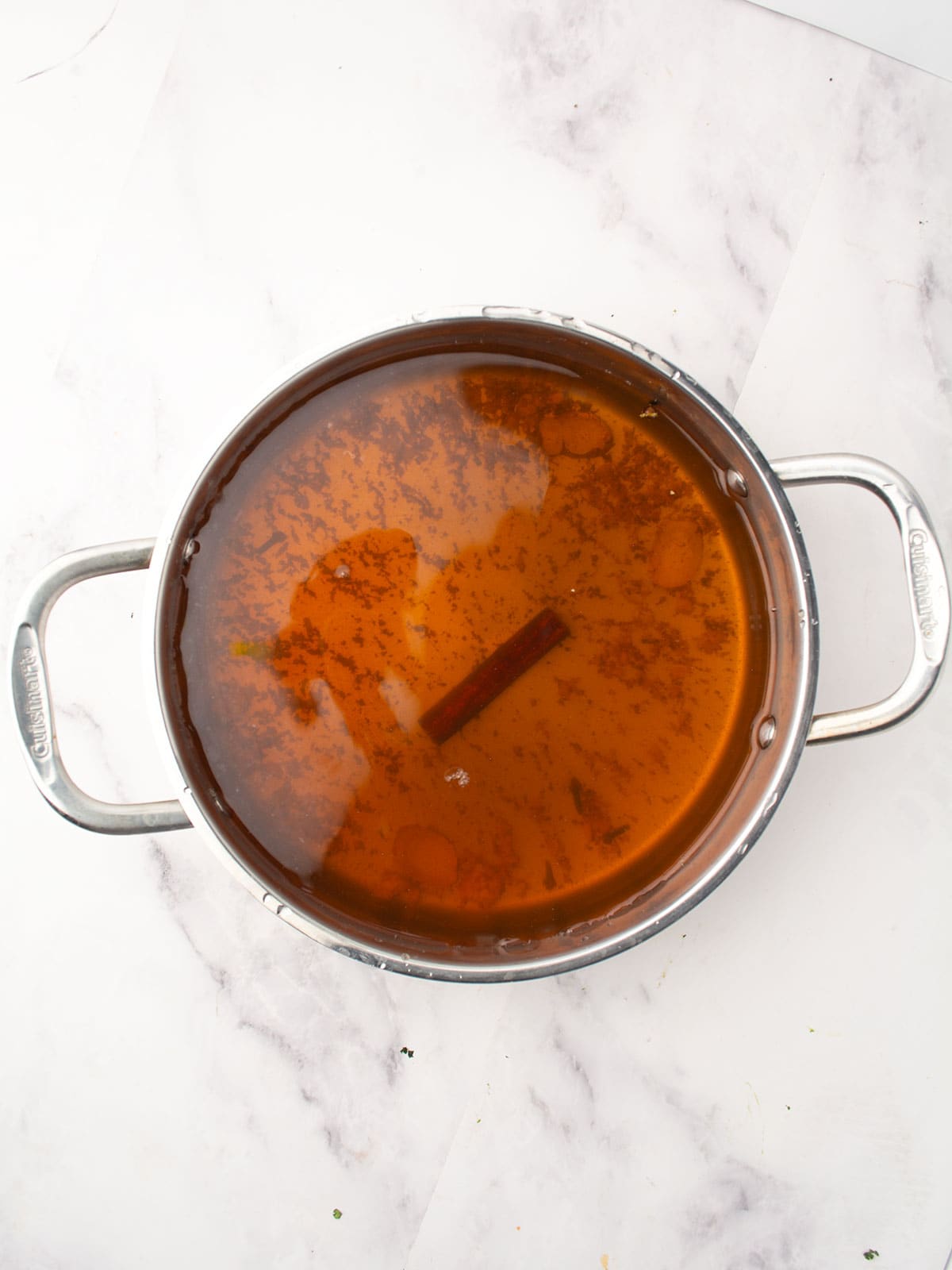 Simmering spices and sugar in a saucepan to prepare syrup