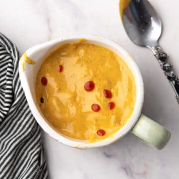 Homemade spicy honey mustard sauce in a small jar, with the spoon