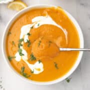 Cozy sweet potato and carrot soup with coconut milk, garnished with parsley