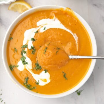 Cozy sweet potato and carrot soup with coconut milk, garnished with parsley