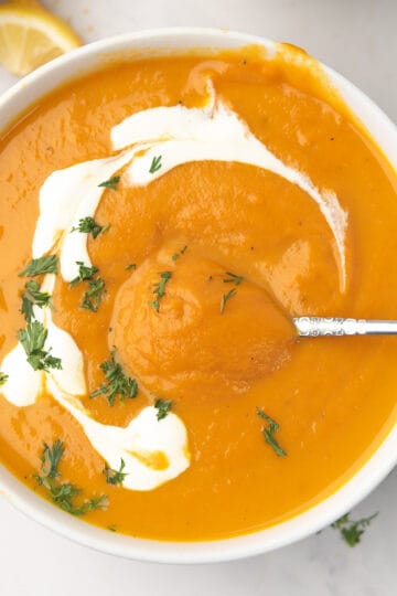 Cozy sweet potato and carrot soup with coconut milk, garnished with parsley