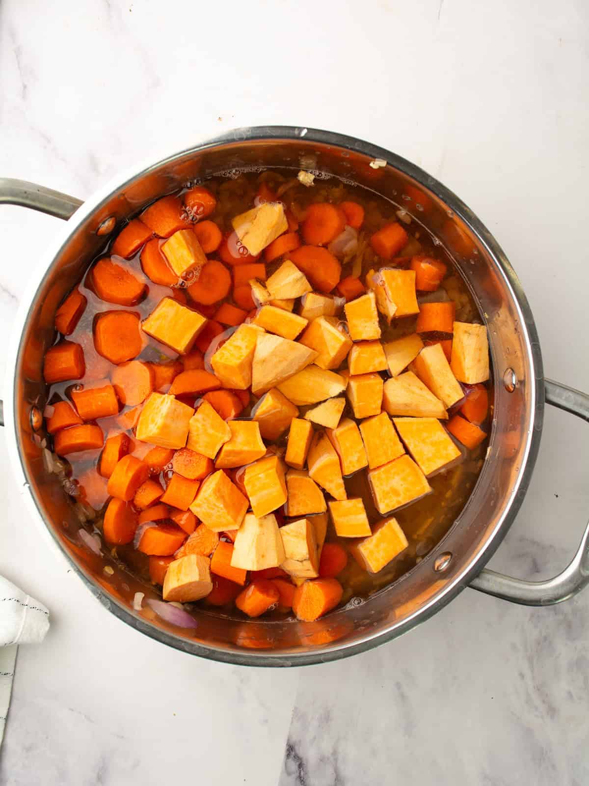 Carrots and sweet potatoes added to the pot