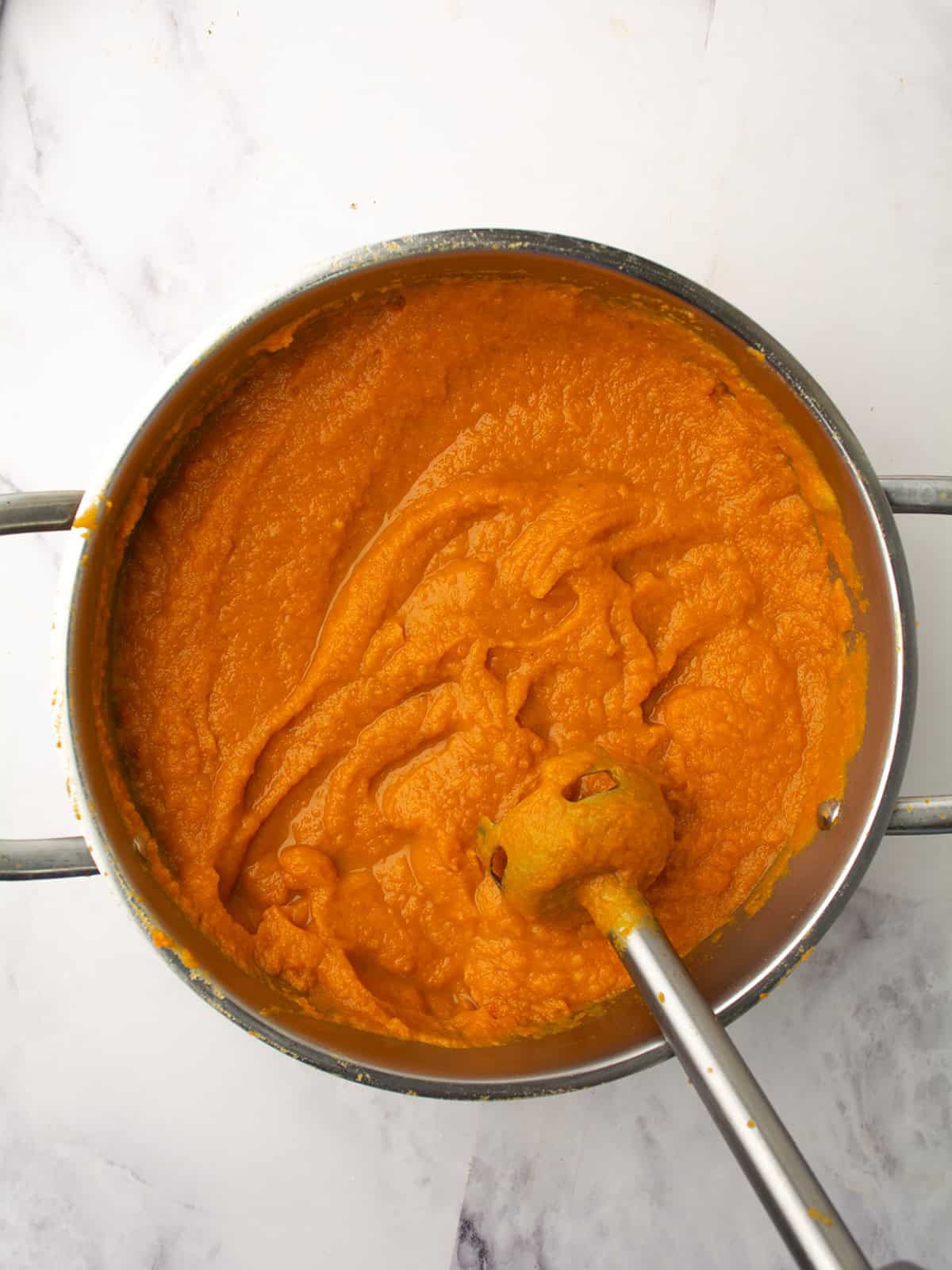 Immersion blender blending sweet potato and carrot soup