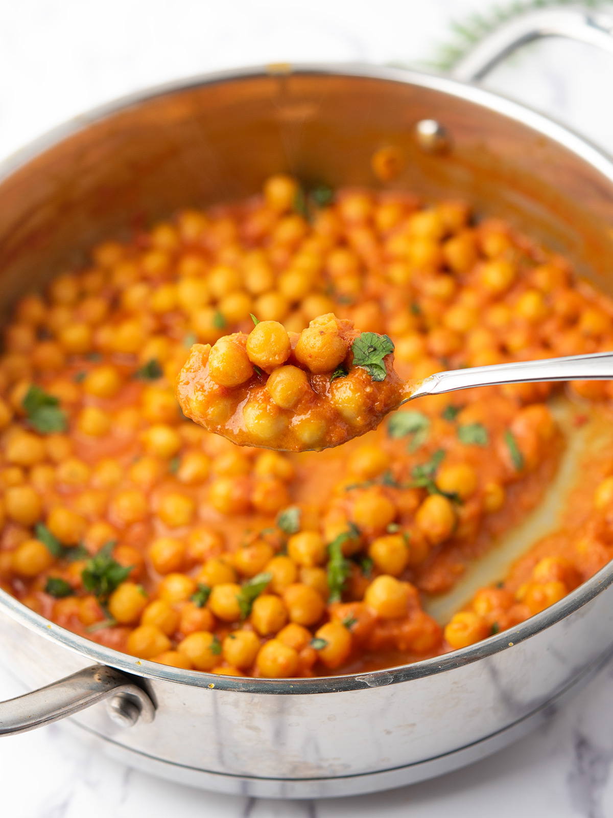 chickpea curry without coconut milk cooked in a pan with a spoon