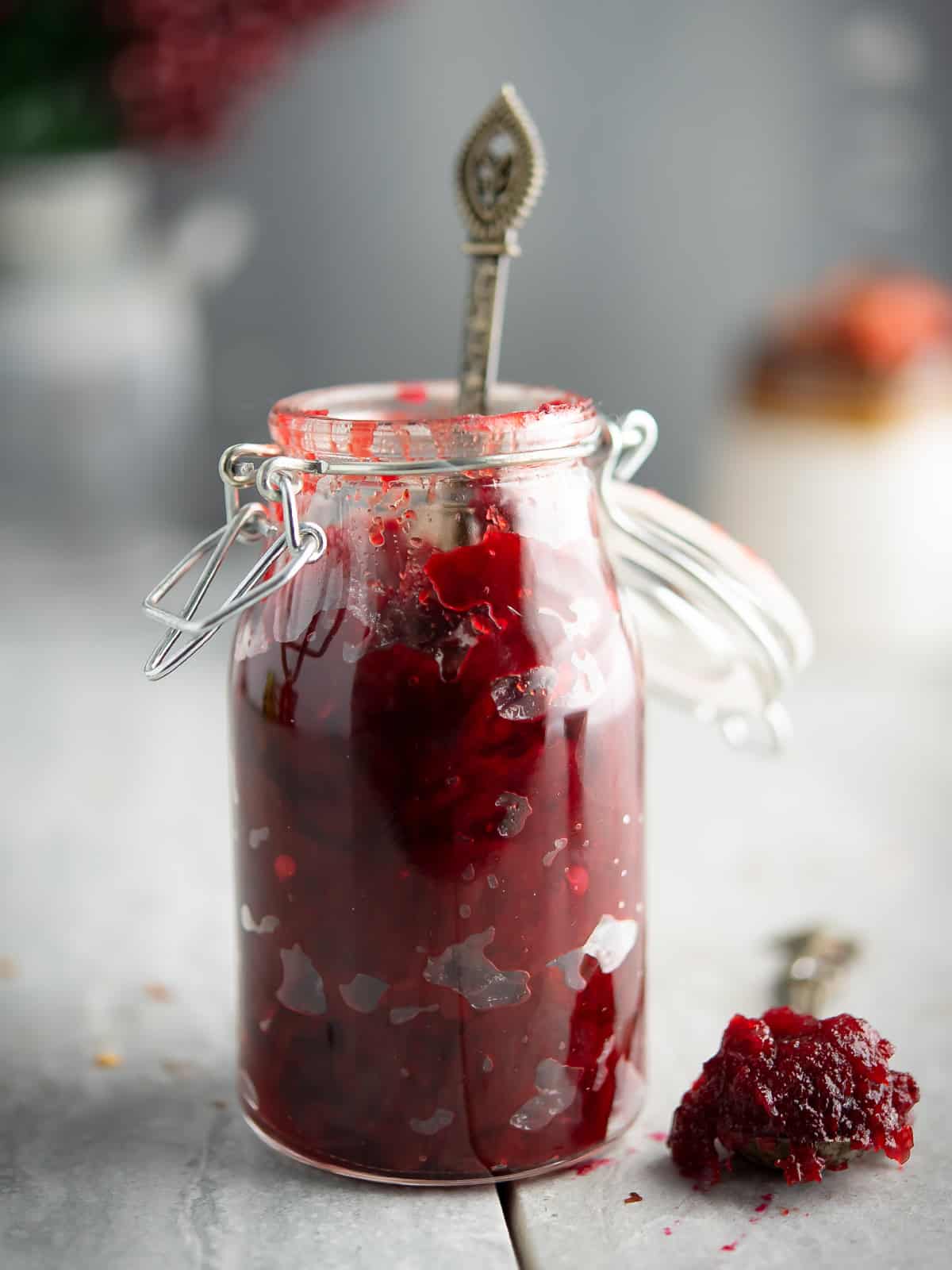 cranberry jalapeno jam stored in a clear glass jar