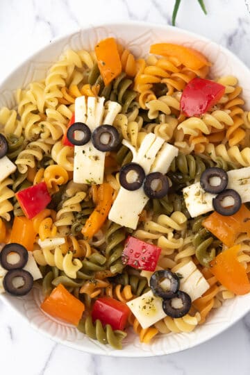 Halloween pasta salad in a bowl with spooky cheese heads
