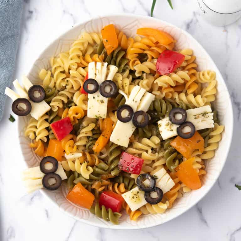 Halloween pasta salad in a bowl with spooky cheese heads