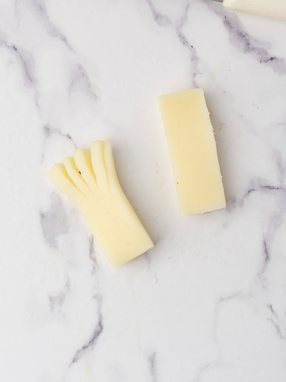 Preparing cheese sticks into monster eyeballs with olive slices.