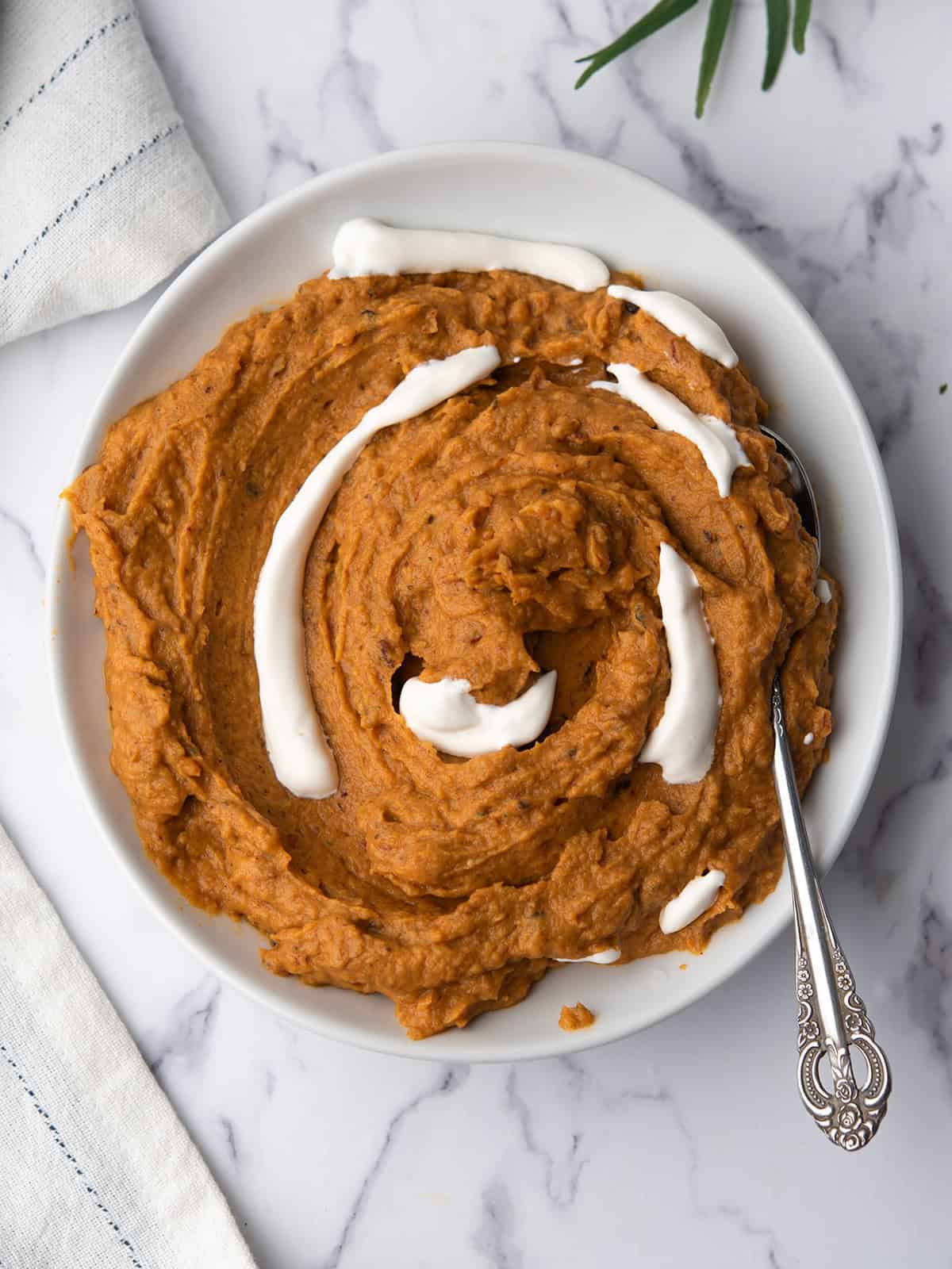 spicy mashed sweet potatoes served in a plate with a spoon