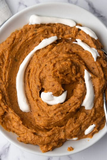 spicy mashed sweet potatoes in a plate with a spoon