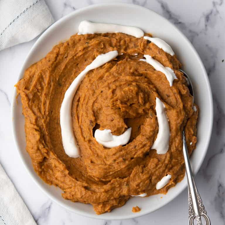 spicy mashed sweet potatoes in a plate with a spoon